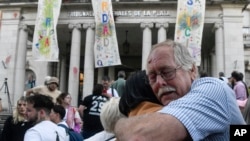 The relative of a victim embraces a person after the reading of the verdict for former police officers on trial for crimes against humanity during the 1976-1983 dictatorship, in La Plata, Argentina,March 26, 2024.