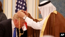 Saudi King Salman presents President Donald Trump with The Collar of Abdulaziz Al Saud Medal at the Royal Court Palace, Saturday, May 20, 2017, in Riyadh. (AP Photo/Evan Vucci)