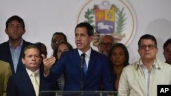 Opposition leader Juan Guaido, center, lawmaker Juan Pablo Guanipa, left, and lawmaker Carlos Eduardo Berrizbeitia, right, give a press conference in Caracas, Venezuela, Jan. 6, 2020.