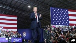 President Donald Trump walks toward the podium to speak at a rally at Total Sports Park, April 28, 2018, in Washington, Mich.