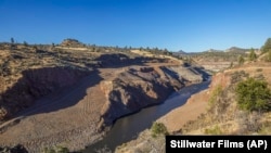 This image provided by Swiftwater Films shows water flowing down the Klamath River where the Iron Gate Dam once stood near Hornbrook, California, Oct. 1, 2024. (Swiftwater Films via AP)