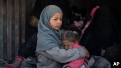 Para pengungsi Suriah, termasuk anak-anak menaiki truk untuk meninggalkan kubu terakhir ISIS di kota Baghouz, Suriah timur, Rabu (20/2). 