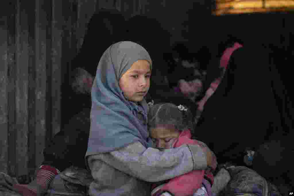 Children ride in the back of a truck that is part of a convoy evacuating hundreds out of the last territory held by Islamic State militants, in Baghouz, eastern Syria.