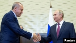 Le président russe Vladimir Poutine serre la main de son homologue turc Tayyip Erdogan lors d'une réunion à Sotchi, en Russie, le 17 septembre 2018.