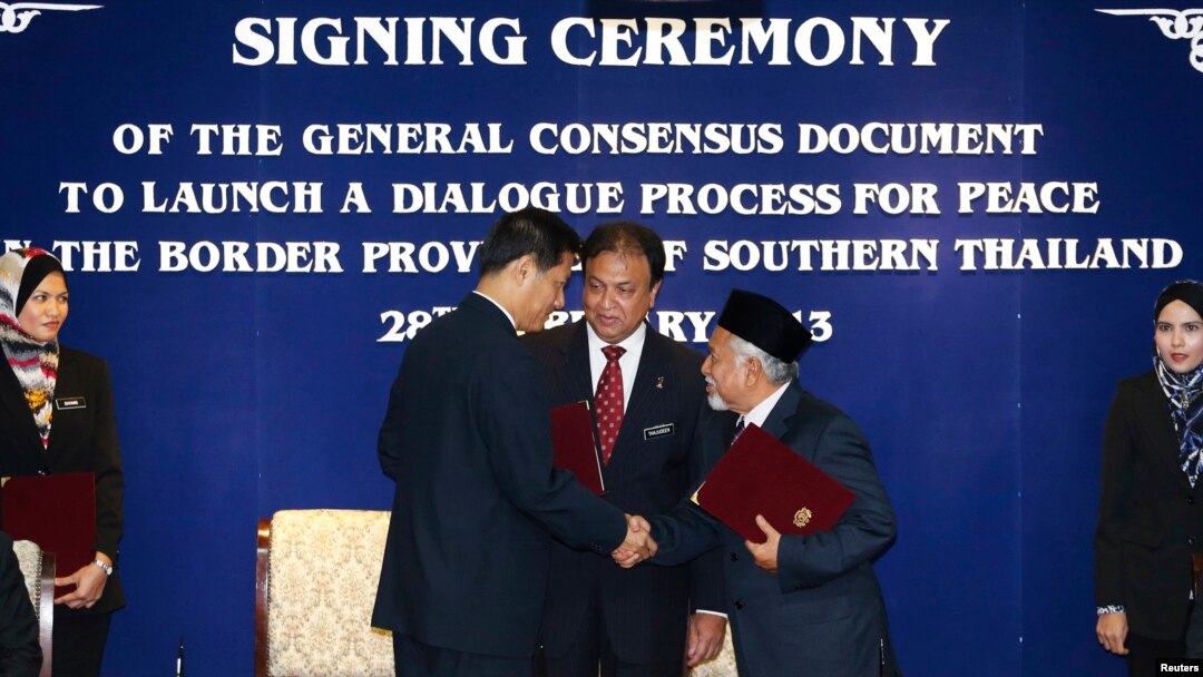 Secretary-General of Thailand's National Security Council, Paradorn Pattanathabutr, center left, shakes hands with chief of Thailand's National Revolution Front (BRN) liaison office in Malaysia, Hassan Taib, center right, Kuala Lumpur, Feb. 28, 2013.