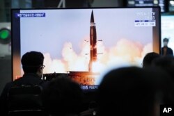 People watch a TV showing an image of North Korea's new guided missile during a news program at the Suseo Railway Station in Seoul, South Korea, Friday. March 26, 2021.