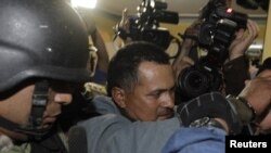 Rubén Villalba, presunto líder de un movimiento de campesinos sin tierra que se enfrentaron con la policía en junio, es escoltado por la policía tras su captura en Asunción. Su abogado, Luis Casabianca presentó un hábeas corpus para que lo liberen.