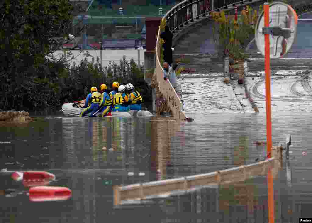 A man talks with rescue workers searching a flooded area in the aftermath of Typhoon Hagibis, in Nagano, Nagano Prefecture, Japan.