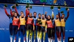 The silver medal team from Russia, (l) gold medal team from Germany, center, and bronze medal team from Latvia (r) pose with flowers after the luge team relay competition at the 2014 Winter Olympics, Feb. 13, 2014, in Krasnaya Polyana, Russia.