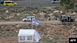 Israeli settlers erect a tin structure and tents in the village of al-Baqa, near the settlement of Kiryat Arba, east of Hebron, West Bank, Dec. 17, 2021.