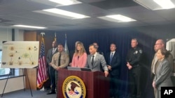 El fiscal federal Martin Estrada observa a la titular de la Administración de Control de Drogas, Anne Milgram, durante una conferencia de prensa, el martes 18 de junio de 2024, en Los Ángeles. 