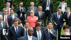 German Chancellor Angela Merkel (C) and U.S. President Barack Obama arrive with other G7 participants for a family picture at the G7 summit at the Elmau castle in Kruen near Garmisch-Partenkirchen, Germany, June 8, 2015. (REUTERS/Christian Hartmann)