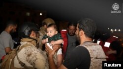 Oficiri saudijske kraljevske mornarice pomažu djetetu na njihovom brodu dok evakuiraju Saudijske i druge državljane brodom Saudijske mornarice iz Sudana kako bi pobjegli od sukoba, Port Sudan