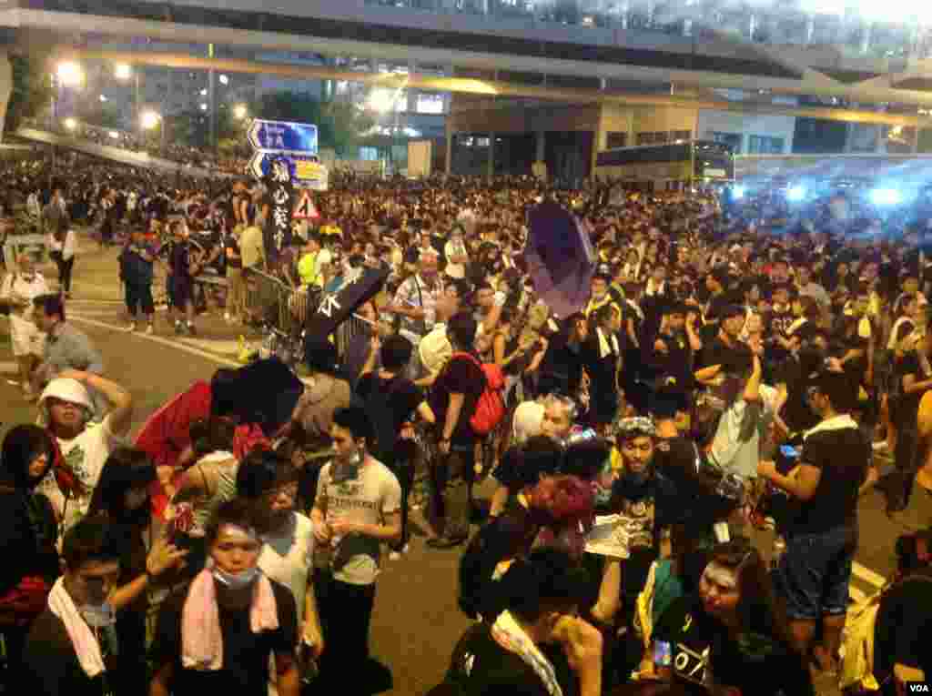 Protestantes continúan bloqueando la calle principal del distrito financiero afuera de las oficinas centrales del gobierno de Hong Kong, a pesar de los esfuerzos de la policía por dispersarlos. 