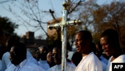 A group of faithfulls pray outside Pretoria's Mediclinic Heart hospital on July 7, 2013, where Former South African president Nelson Mandela lays in critical condition.