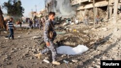 Kurdish security forces inspect the site of a car bomb attack in Kirkuk Aug. 23, 2014.