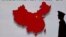 FILE - A security guard stands close to an electronic screen featuring a map of China.