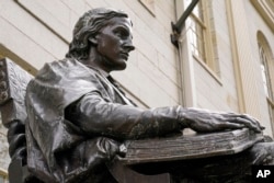 The statue of John Harvard, founder of Harvard College, is seen in Harvard Yard, Wednesday, April 27, 2022, on the campus of Harvard University in Cambridge, Mass.  In Harvard's pledge to atone for its ties to slavery, it identified dozens of people who were enslaved by the university's early leaders and faculty.  (AP Photo/Charles Krupa)