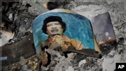 Picture of Libya's ousted leader Moammar Gadhafi among ashes in downtown Sirte, Wed., Oct. 12, 2011.