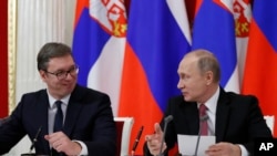 Russian President Vladimir Putin, right, and Serbian President Aleksandar Vucic talk to each other during a meeting with the media following their talks in the Kremlin in Moscow, Russia, Dec. 19, 2017. 