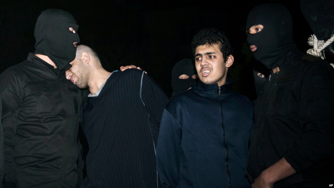 Phạm nhân Alireza Mafiha, thứ nhì từ trái, tựa đầu vào vài một nhân viên an ninh trước lúc án tử hình được thi hành, 