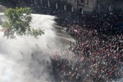 Police spray water on anti-government demonstrators in Santiago, Chile, Oct. 28, 2019.