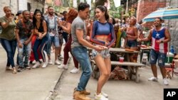 This image released by Warner Bros. Picures shows Anthony Ramos, foreground left, and Melissa Barrera in a scene from 'In the Heights.'