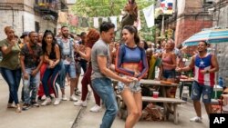 This image released by Warner Bros. Picures shows Anthony Ramos, foreground left, and Melissa Barrera in a scene from "In the Heights."