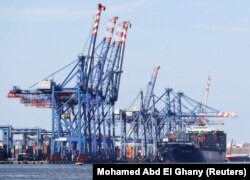 Un porte-conteneurs est vu à côté de grues sur le canal de Suez près de la ville portuaire d'Ismaïlia, au nord-est du Caire, en Égypte, le 5 mars 2021.