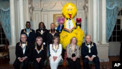 Front row from left, 2019 Kennedy Center Honorees Michael Tilson Thomas, Linda Ronstadt, Sally Field, Joan Ganz Cooney, and Lloyd Morrisett, back row (l-r), Philip Bailey, Verdine White, Ralph Johnson, and characters from "Sesame Street," Dec. 7, 2019. 