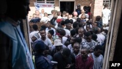 Voters queue outside the polling station at the Institut Zanner in Goma on December 20, 2023.