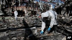 FILE - Forensics experts gather evidence in the rubble of a funeral hall destroyed by a deadly Saudi-led airstrike in Sana'a, Yemen, Oct. 8, 2016.