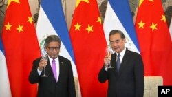 El ministry de Relaciones Exteriores de El Salvador, Carlos Castañeda y su homólogo de China, Wang Yi celebran la firma del establecimiento de relaciones diplomáticas entre El Salvador y China en Beijing, China, el martes, 21 de agosto de 2018.