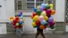 Varias personas llevan globos a una marcha en el Día Internacional de los Trabajadores en Santiago, Chile, el miércoles 1 de mayo de 2024. (Foto AP/Matías Basualdo)