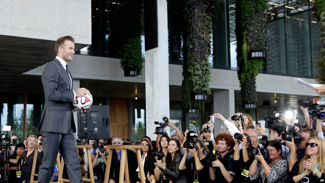 Mantan bintang sepakbola Inggris David Beckham memegang bola di konferensi pers ketika ia mengumumkan akan membeli tim ekspansi Major League Soccer, Miami, 5 Februari 2014.