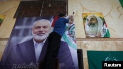 Një njeri var fotografinë e udhëheqësit të Hamasit Ismail Haniyeh, i cili u vra të mërkurën në mëngjes në Iran, në një kamp refugjatësh palestinezë në Bejrut, Liban, më 31 korrik, 2024/Reuters