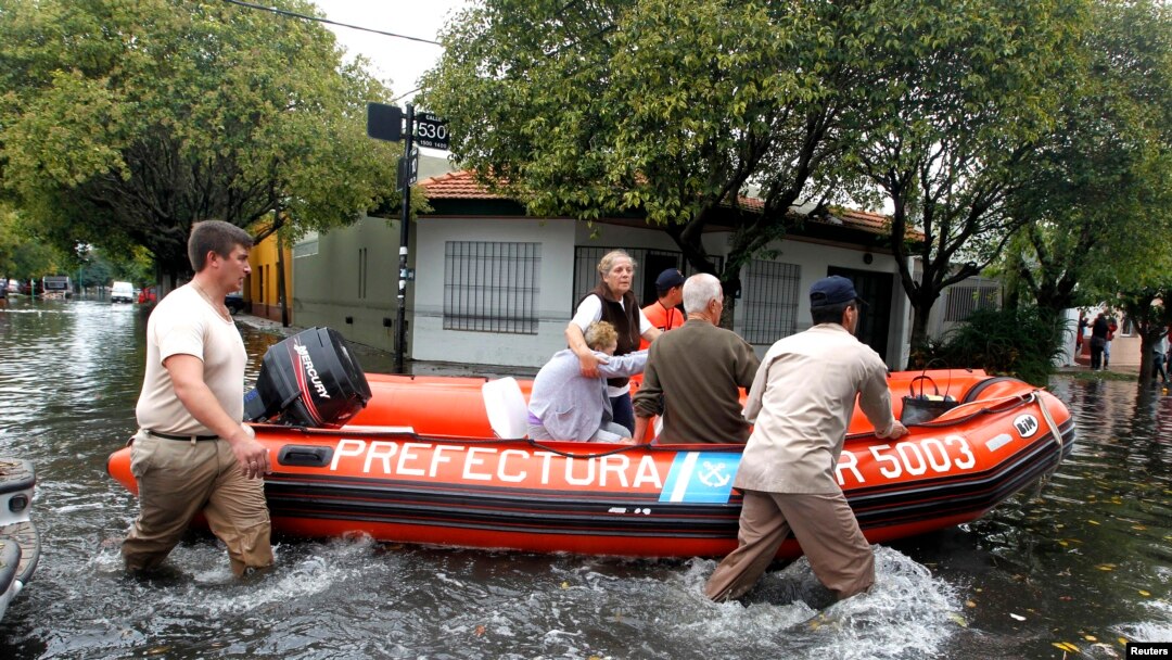 Miembros de la Guardia Costera argentina evacúan a dos mujeres en La Plata, capital de la provincia de Buenos Aires. El Papa ha hecho un llamado a la solidaridad para con sus compatriotas.