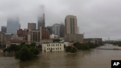 FILE - Floodwaters from Tropical Storm Harvey overflow from Buffalo Bayou in downtown Houston, Texas, Aug. 28, 2017.