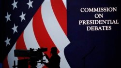 A cameraman is silhouetted against an an American flag during preparations for the presidential debate at Hofstra University in Hempstead, N.Y., Sept. 25, 2016.