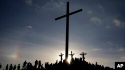 Flanqueados por La Cruz del El Morro, penitentes recrean la crucifixión de Jesucristo, el viernes, 30 de marzo, de 2018, durante la celebración del Vienes Santo.