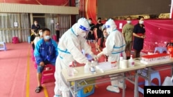 中國雲南邊境城市瑞麗民眾在排隊接受新冠病毒核酸檢測。 （2021年7月5日）