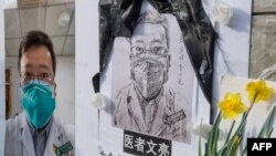 FILE - Chinese students and their supporters hold a memorial for Dr. Li Wenliang, who was the whistleblower of COVID-19, that originated in Wuhan, and caused the doctors death, outside UCLA campus in Westwood, California, Feb. 15, 2020.