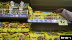 A worker arranges packets of Nestle's Maggi noodles on a shelf inside a Reliance supermarket in Mumbai, India, March 16, 2021.