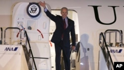 El vicepresidente Joe Biden saluda a su llegada a Tokio.
