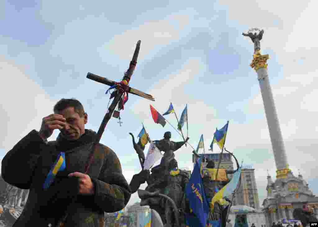 Một người biểu tình ủng hộ châu Âu làm dấu thánh giá trong một thánh lễ trên Quảng trường Độc lập ở Kyiv. Phe đối lập Ukraina ngồi xuống đàm phán với Tổng thống Yanukovych lần đầu tiên vào hôm thứ Sáu kể từ khi cuộc biểu tình nổ ra ba tuần trước.