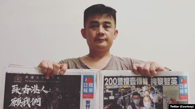 欧彪峰手持香港苹果日报表达支持港人民主诉求。(欧彪峰推特图片)