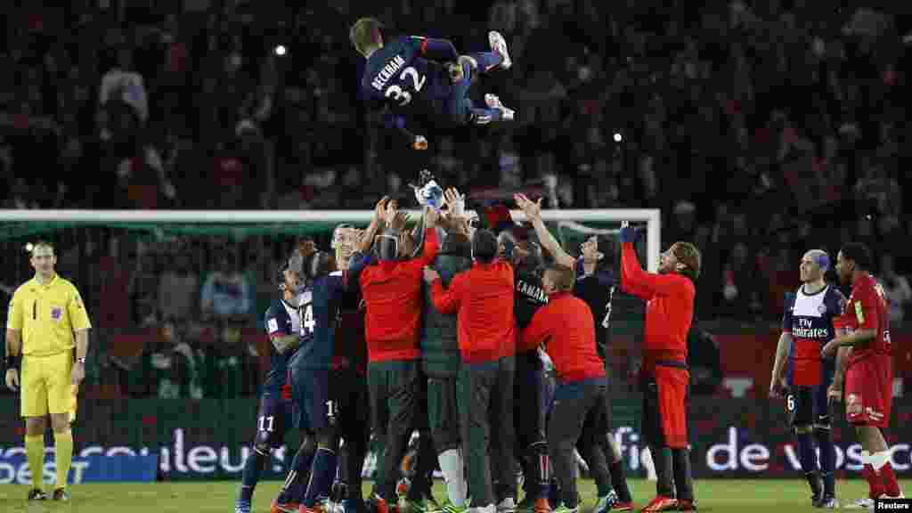 Paris Saint-Germain players throw David Beckham in the air at the end of their team's French Ligue 1 soccer match against Brest in Paris May 18, 2013.
