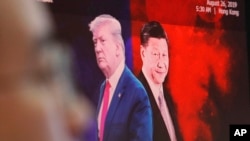 Un écran d'ordinateur montre des images du président chinois Xi Jinping, à droite, et du président américain Donald Trump, le 26 août 2019. (AP Photo / Ahn Young-joon, fichier)