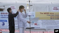 Seorang pasien memakai masker untuk melindungi diri dari penyakit MERS, di Seoul National University Hospital, Korea Selatan (1/6). (AP/Ahn Young-joon)