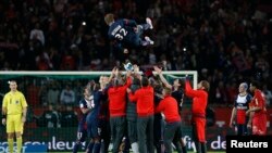 Paris Saint-Germain players throw David Beckham in the air at the end of their team's French Ligue 1 soccer match against Brest at the Parc des Princes stadium in Paris May 18, 2013. David Beckham broke down in tears as he was substituted in the 81st minu